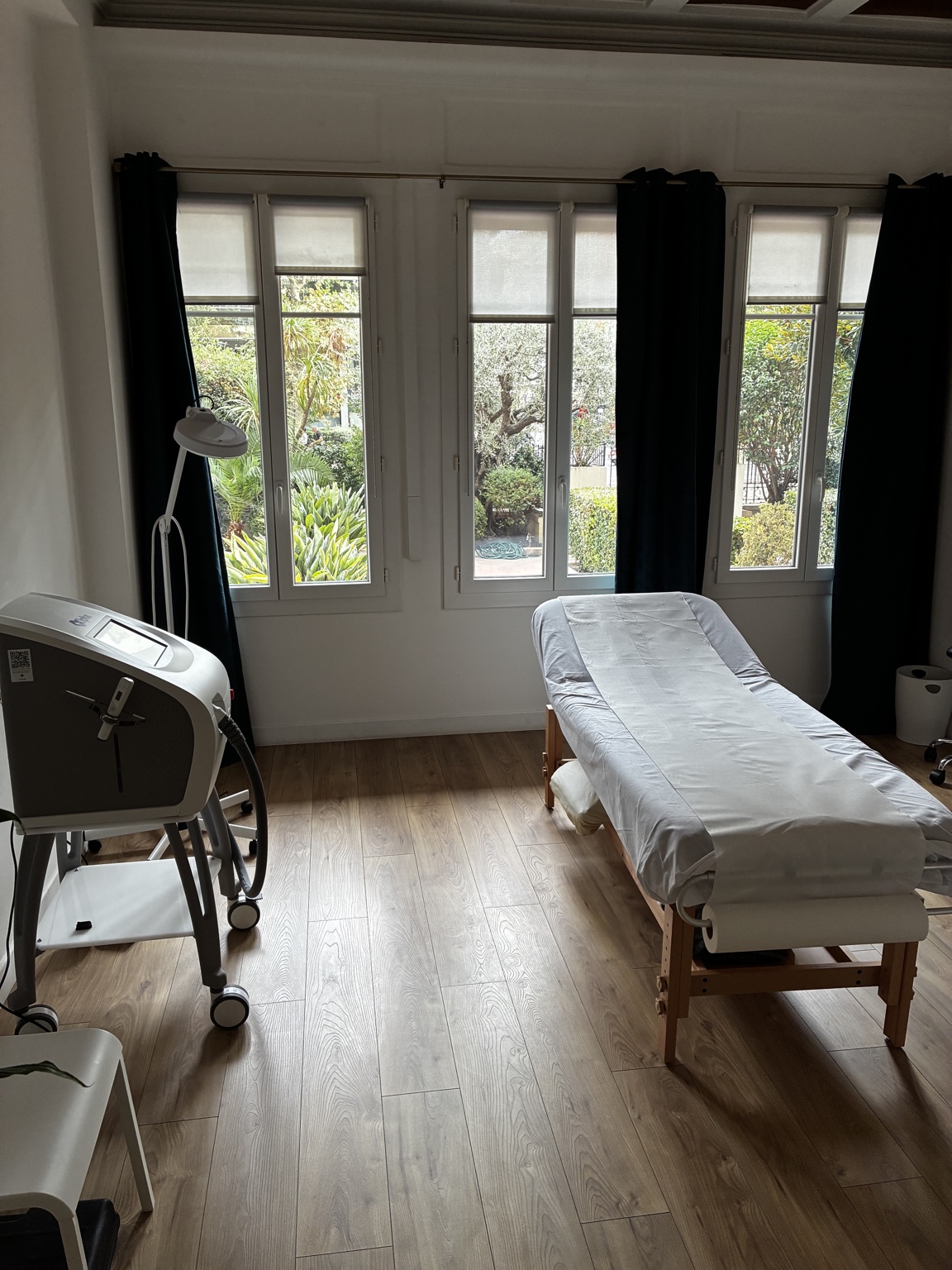 Salle de soins équipée avec table de soin près de la fenêtre